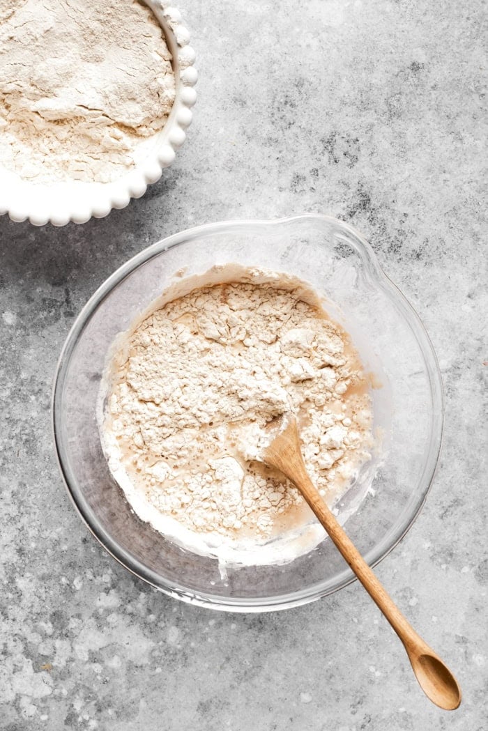 This homemade English Muffin Bread is incredibly easy, with no kneading required, and it will make your morning toast extra delicious! Stirring flour into liquid ingredients for dough
