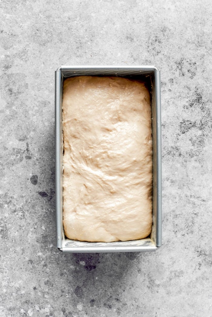 This homemade English Muffin Bread is incredibly easy, with no kneading required, and it will make your morning toast extra delicious! Overhead view of English muffin bread dough in pan