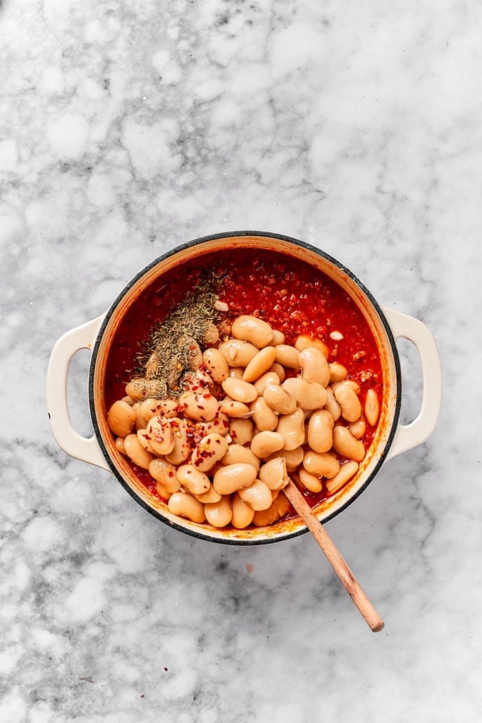 Lasagna beans pair creamy gigante beans with zippy tomato sauce, Italian sausage and ricotta, and it's all topped with even more cheese. Yum! Gigante beans added to pot of tomato sauce with seasonings