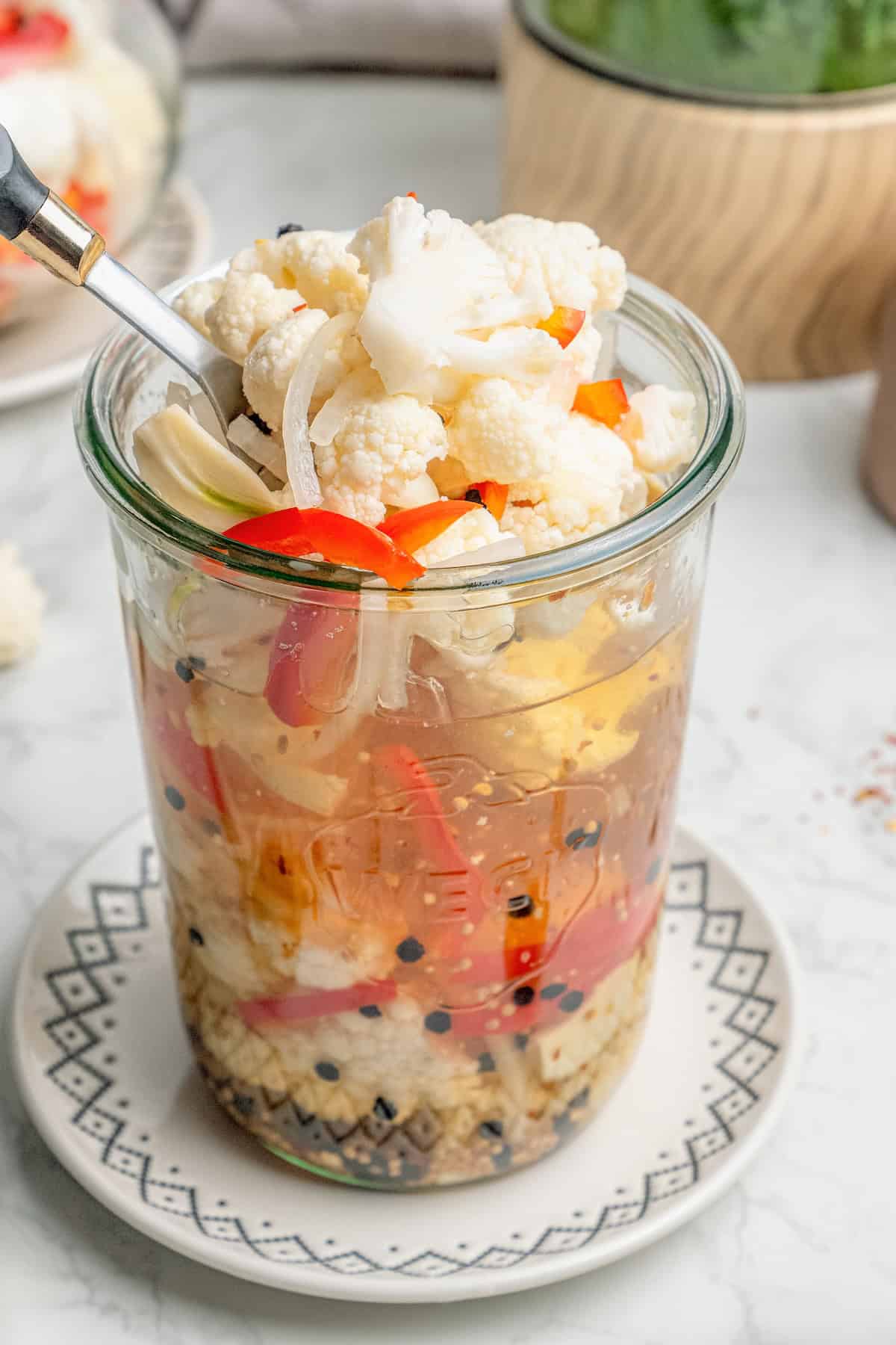 a fork scooping pickled cauliflower out of a jar
