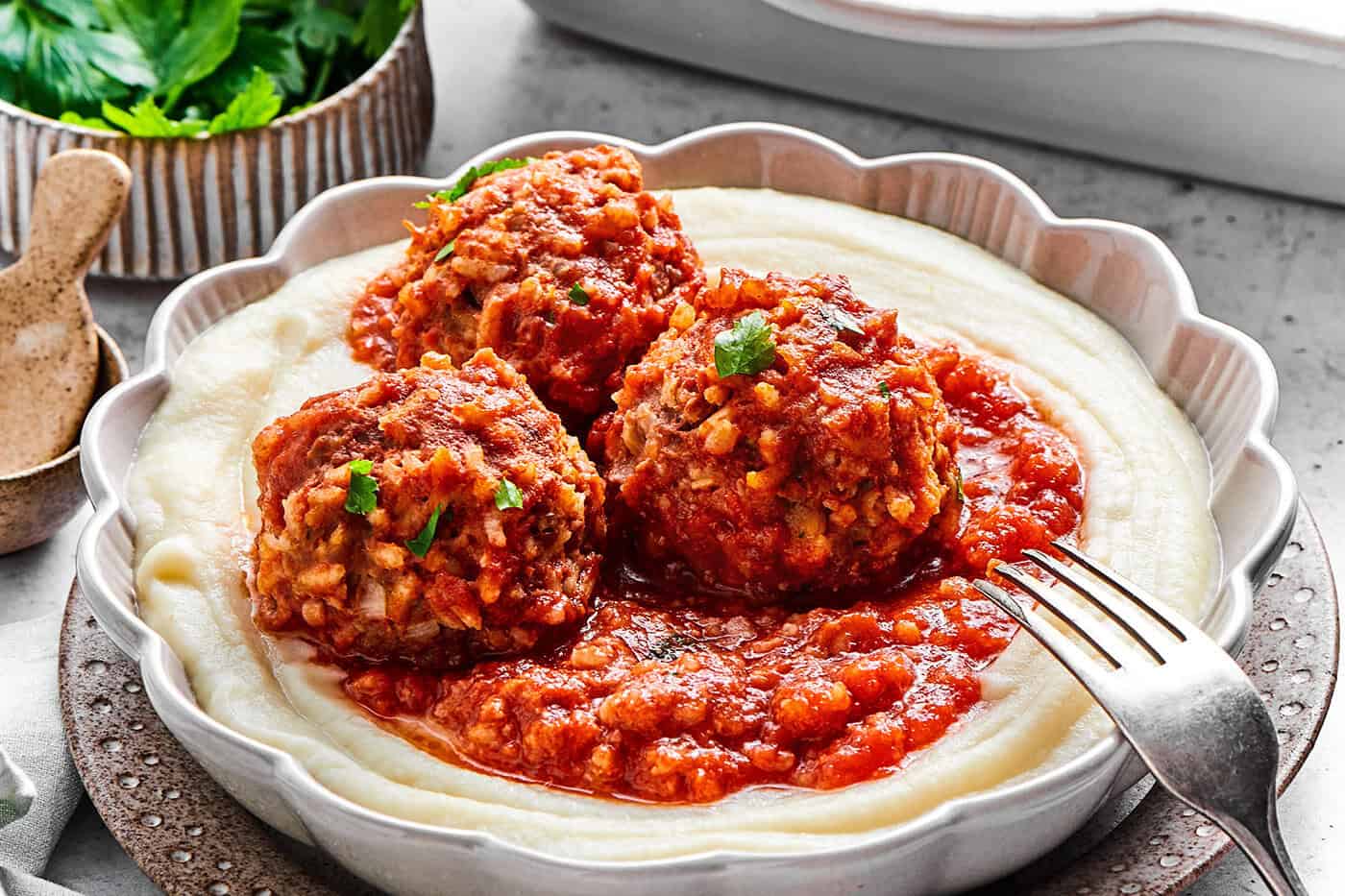 Tender beef and rice Porcupine Meatballs are smothered in tomato sauce to make a savory, filling dish that's perfect with mashed potatoes. 3 porcupine meatballs with red sauce, over creamy mashed potatoes