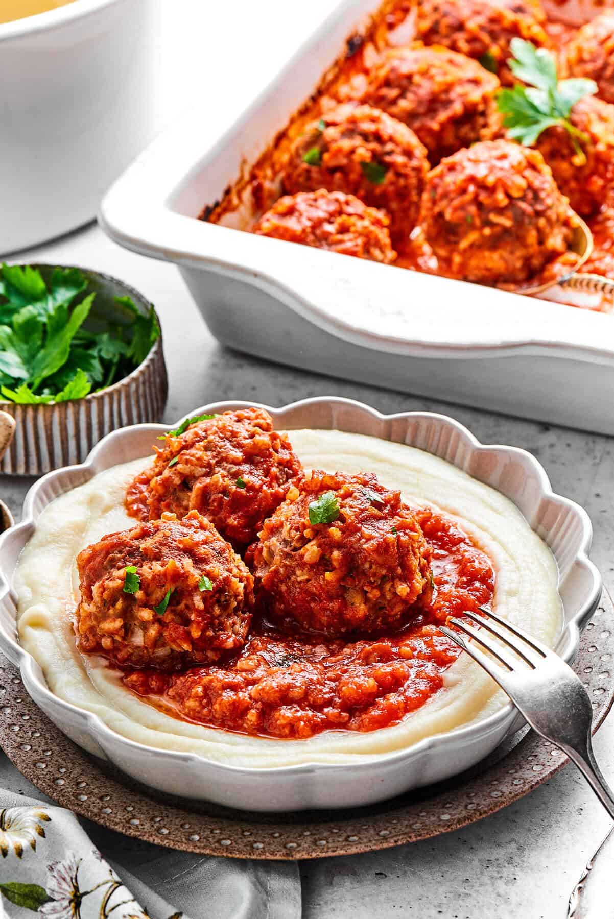 Tender beef and rice Porcupine Meatballs are smothered in tomato sauce to make a savory, filling dish that's perfect with mashed potatoes. 3 porcupine meatballs with red sauce, over creamy mashed potatoes