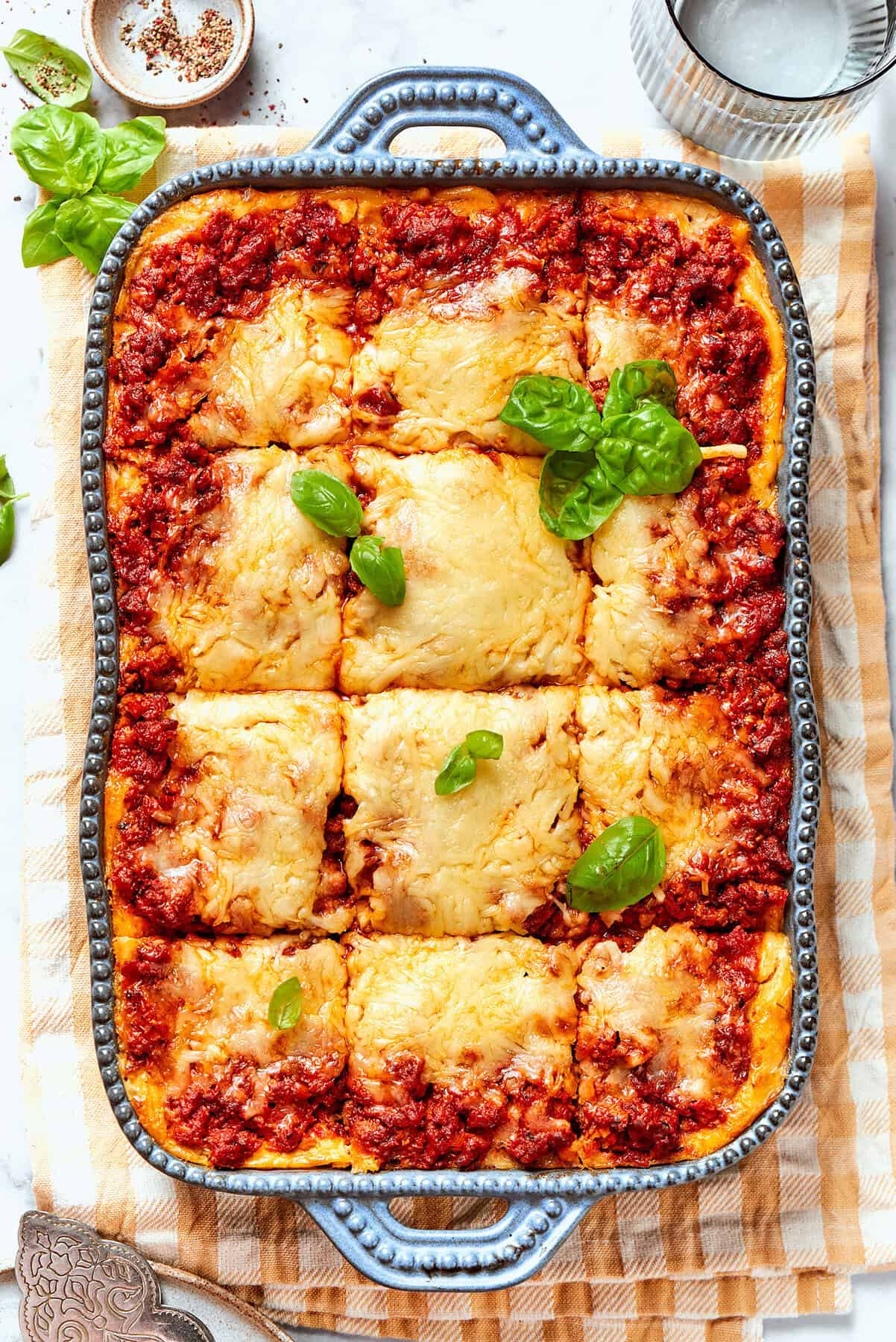 overhead photo of baked spaghetti casserole cut into individual pieces