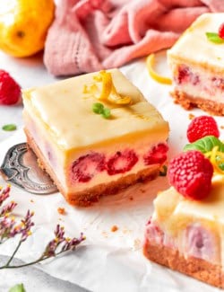 a serving spatula holding a lemon raspberry cheesecake bar