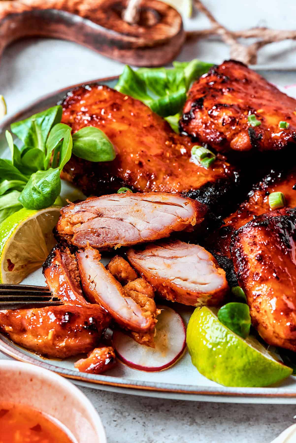 lemongrass chicken thighs on a platter, with one cut into pieces