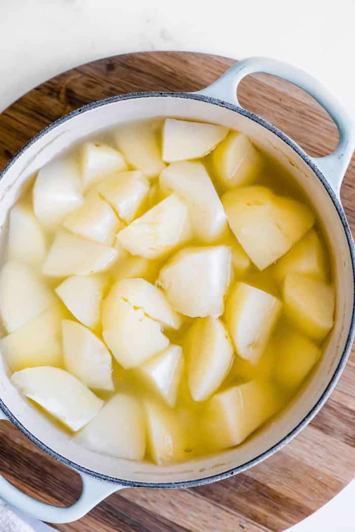 peeled potatoes in a pot of water
