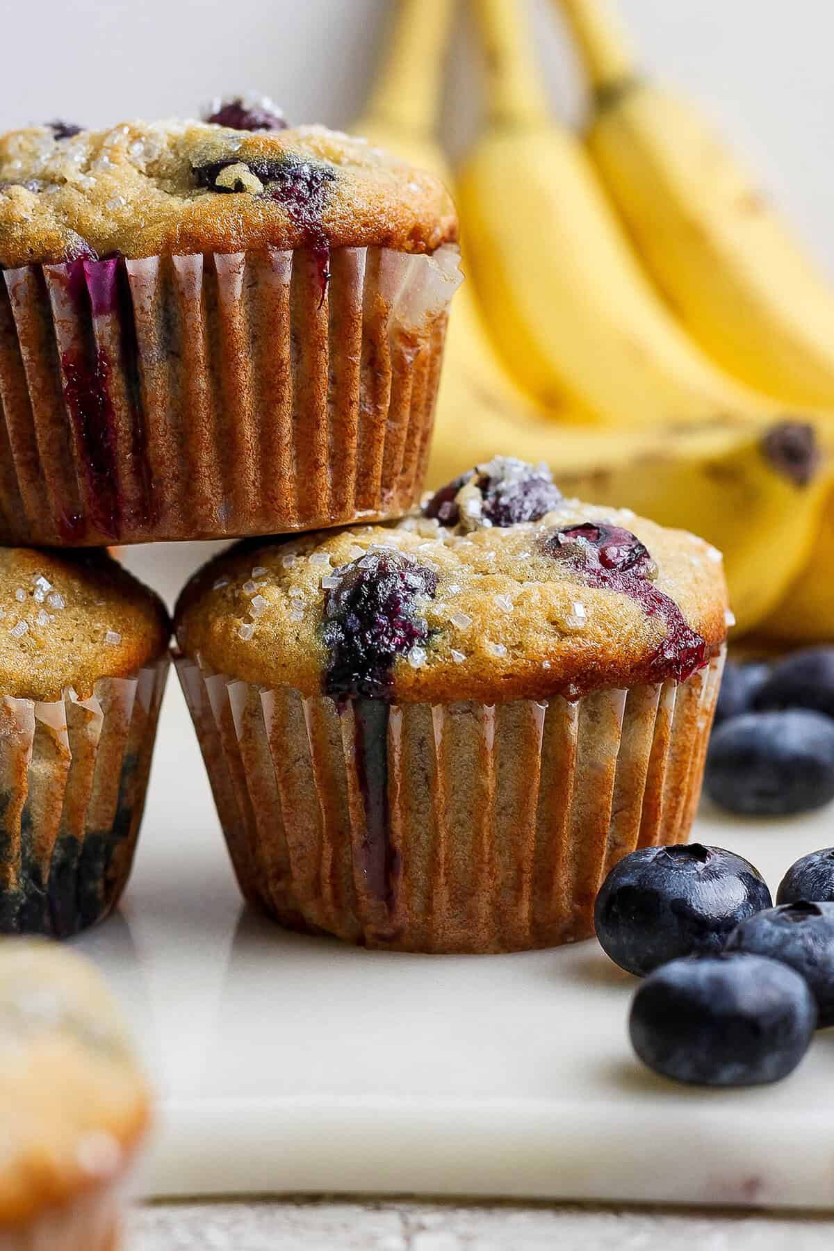 Banana Blueberry Muffins combine two classic recipes into one moist, lofty, perfectly sweet muffin package. They're such a treat! Closeup of 3 stacked banana blueberry muffins