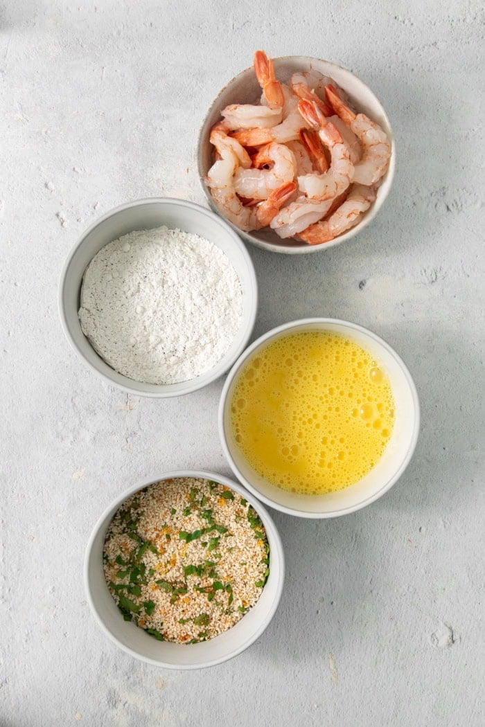 These butterfly shrimp are tender and juicy on the inside, crisp and crunchy on the outside, and paired with a spicy creamy cocktail sauce! Overhead view of dredging station for butterfly shrimp