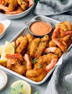 Butterfly shrimp in tray with cocktail sauce and lemon wedges