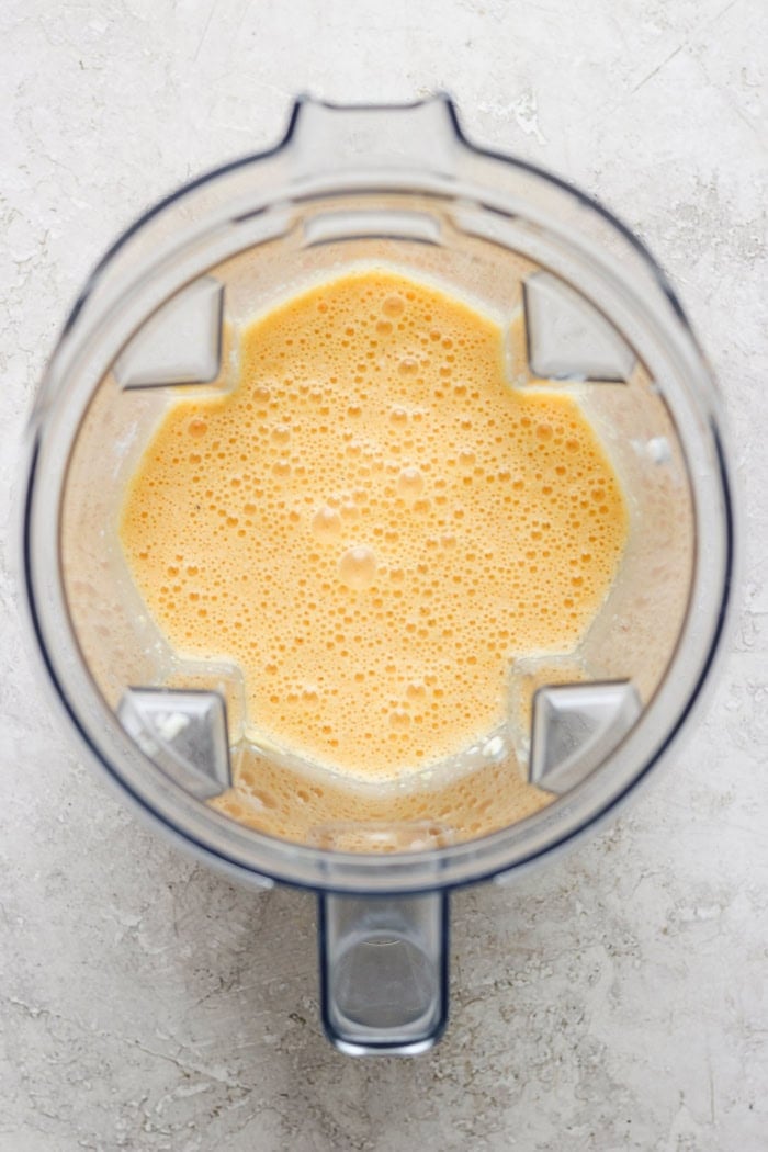 Cottage Cheese Egg Bites are creamy, cheesy and packed with protein. And let’s not forget the bacon! The perfect savory meal prep breakfast. Overhead view of egg mixture in blender