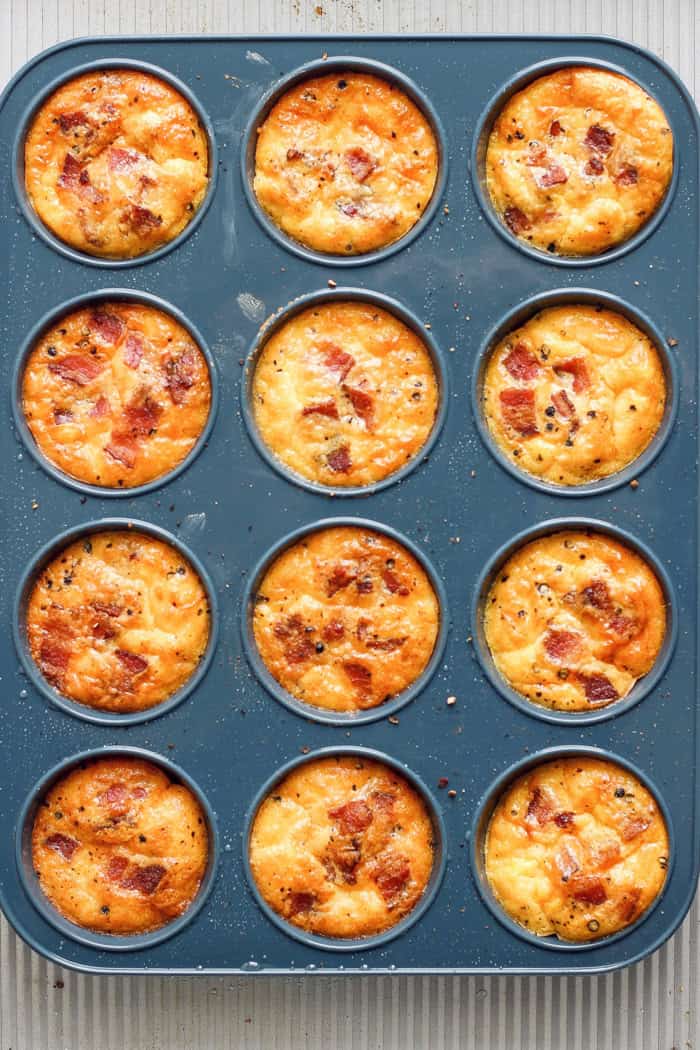 Cottage Cheese Egg Bites are creamy, cheesy and packed with protein. And let’s not forget the bacon! The perfect savory meal prep breakfast. Overhead view of baked cottage cheese egg bites in muffin pan