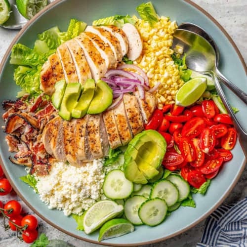 overhead photo of grilled chicken salad on a blue serving platter
