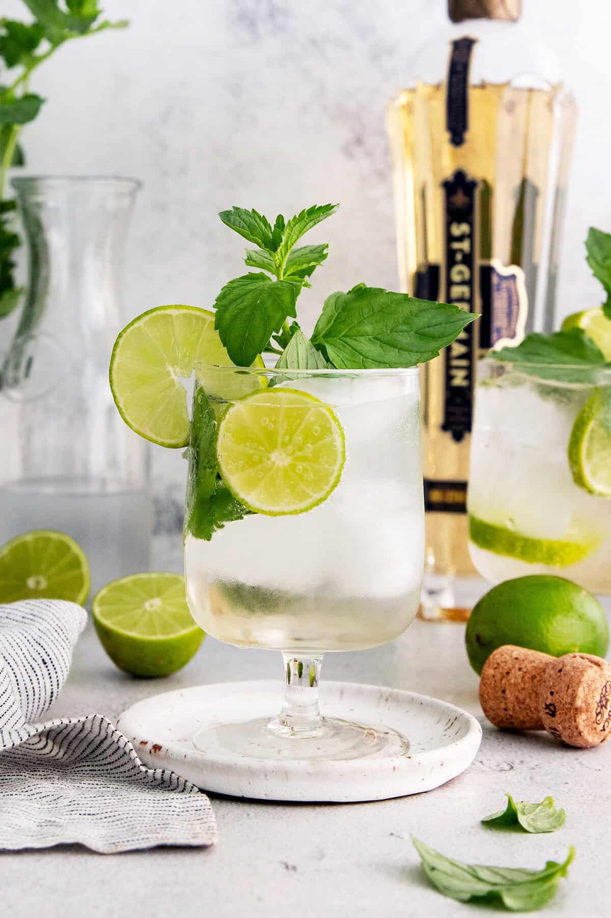 This fizzy Hugo spritz is easy to make, with a crisp, refreshing flavor and a little bit of floral complexity thanks to elderflower liqueur. Hugo spritz cocktail in glass with sprig of mint and lime wheels