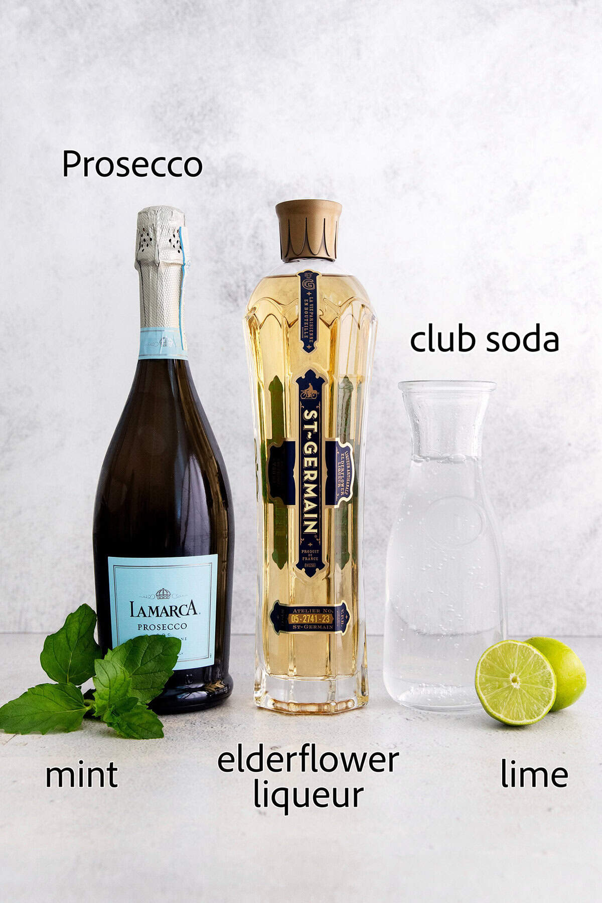 This fizzy Hugo spritz is easy to make, with a crisp, refreshing flavor and a little bit of floral complexity thanks to elderflower liqueur. Overhead view of ingredients for Hugo spritz cocktail