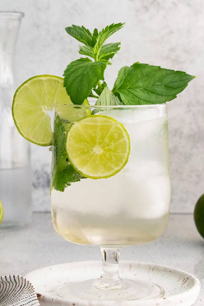 This fizzy Hugo spritz is easy to make, with a crisp, refreshing flavor and a little bit of floral complexity thanks to elderflower liqueur. Hugo spritz cocktail in glass with lime wheels and mint sprigs