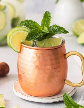 Copper mug with Moscow mule mocktail garnished with fresh lime and mint