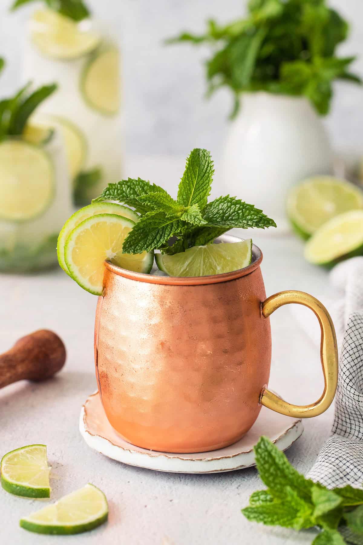 This easy Moscow Mule Mocktail has the bold ginger, tart lime and refreshing mint flavor you love, minus the alcohol. Perfect for summer! Copper mug with Moscow mule mocktail garnished with fresh lime and mint