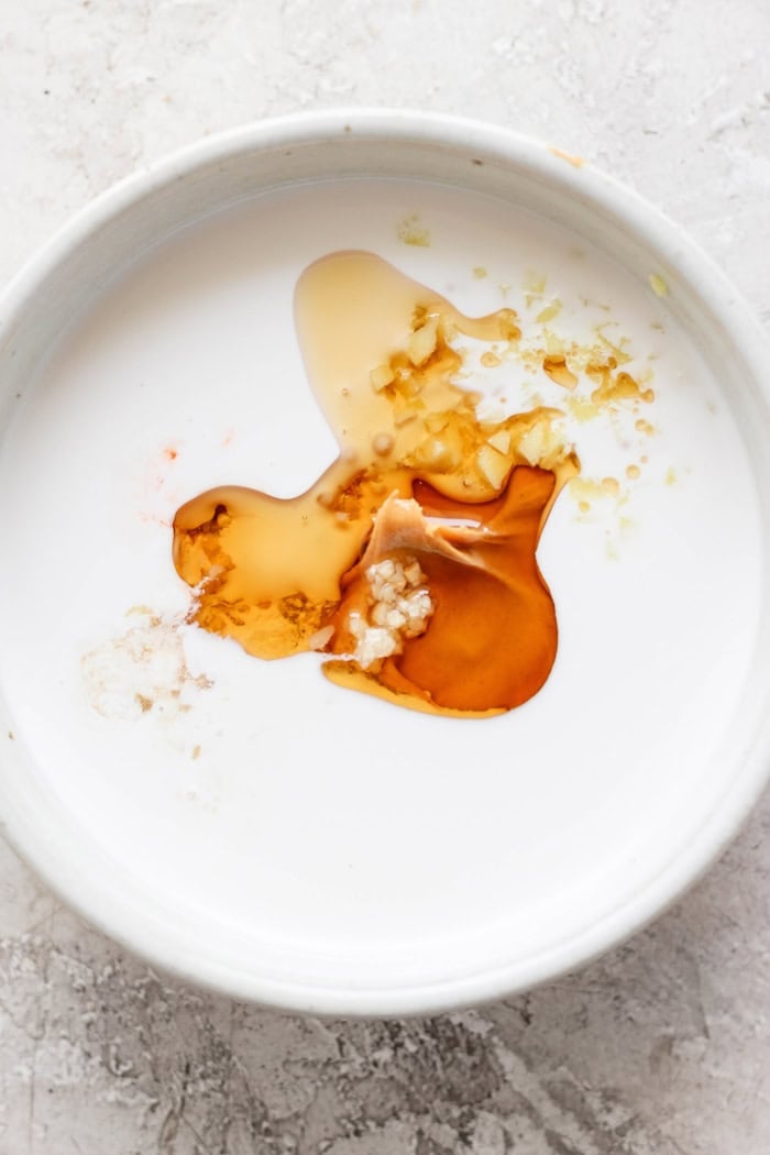 This homemade peanut sauce is creamy and sweet, but also tangy, garlicky, and just a little bit spicy. But best of all, it's SO easy to make! Ingredients for peanut sauce in bowl before stirring