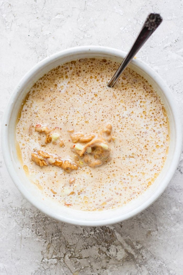 This homemade peanut sauce is creamy and sweet, but also tangy, garlicky, and just a little bit spicy. But best of all, it's SO easy to make! Stirring together homemade peanut sauce in bowl