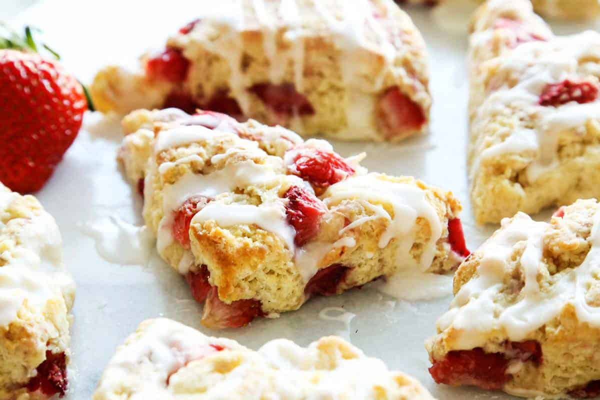 These homemade Strawberry Scones are buttery and golden, and studded with fresh berries. A drizzle of vanilla glaze is the perfect finish! strawberry scones with fresh strawberries and a powdered sugar glaze