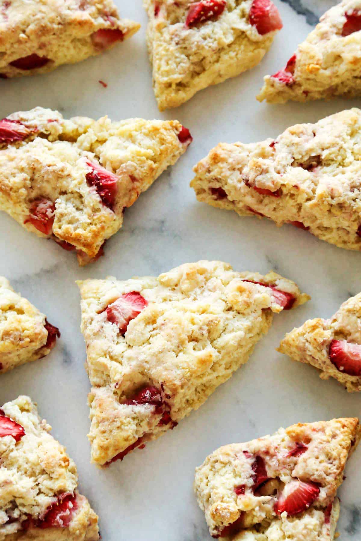 These homemade Strawberry Scones are buttery and golden, and studded with fresh berries. A drizzle of vanilla glaze is the perfect finish! overhead photo of fresh strawberry scones, without the glaze