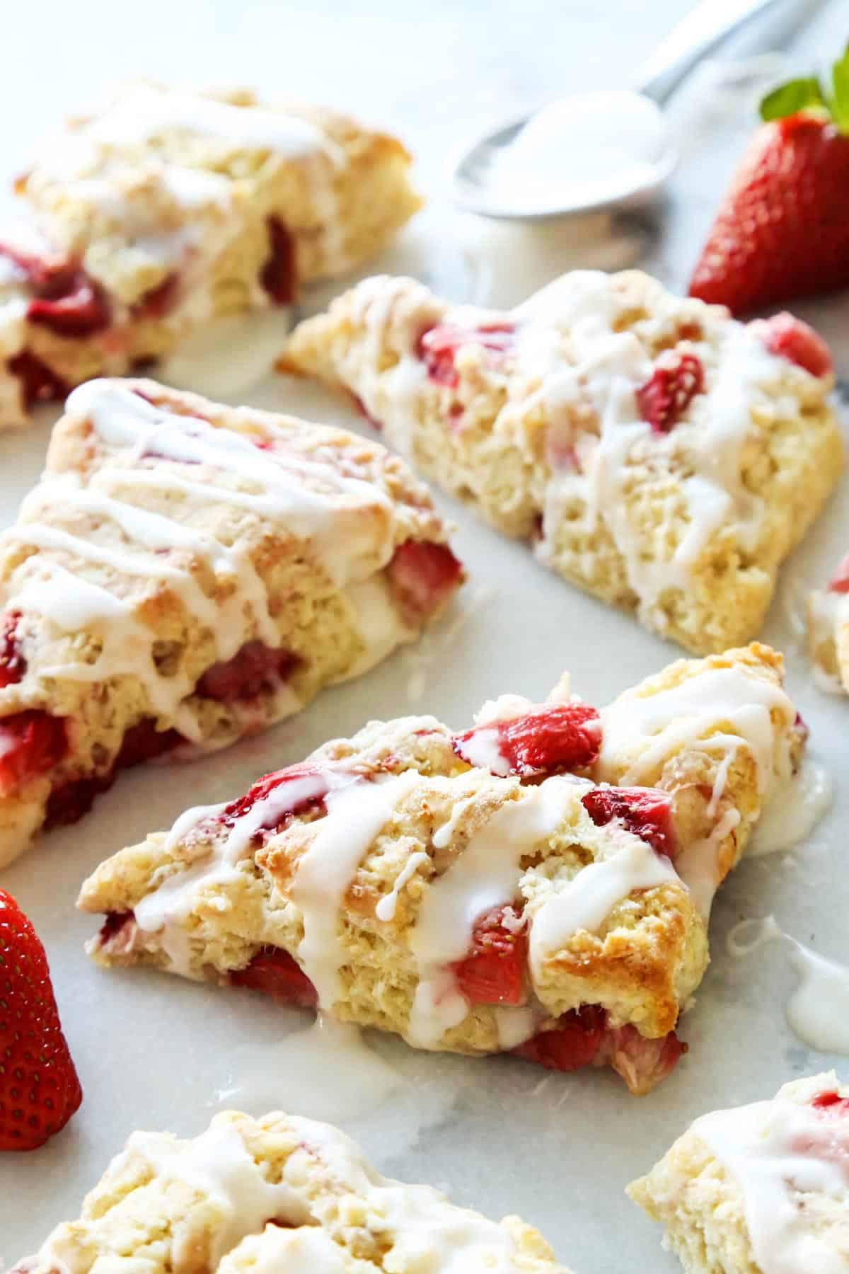 These homemade Strawberry Scones are buttery and golden, and studded with fresh berries. A drizzle of vanilla glaze is the perfect finish! fresh strawberry scones with a powdered sugar glaze