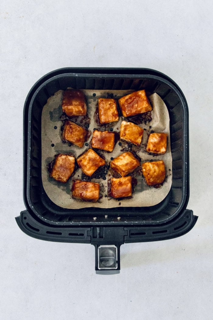 Teriyaki salmon bowls are an easy dinner ready in less than 20 minutes, with tender salmon, sticky teriyaki sauce, and lots of fresh veggies! Overhead view of teriyaki salmon bites in air fryer