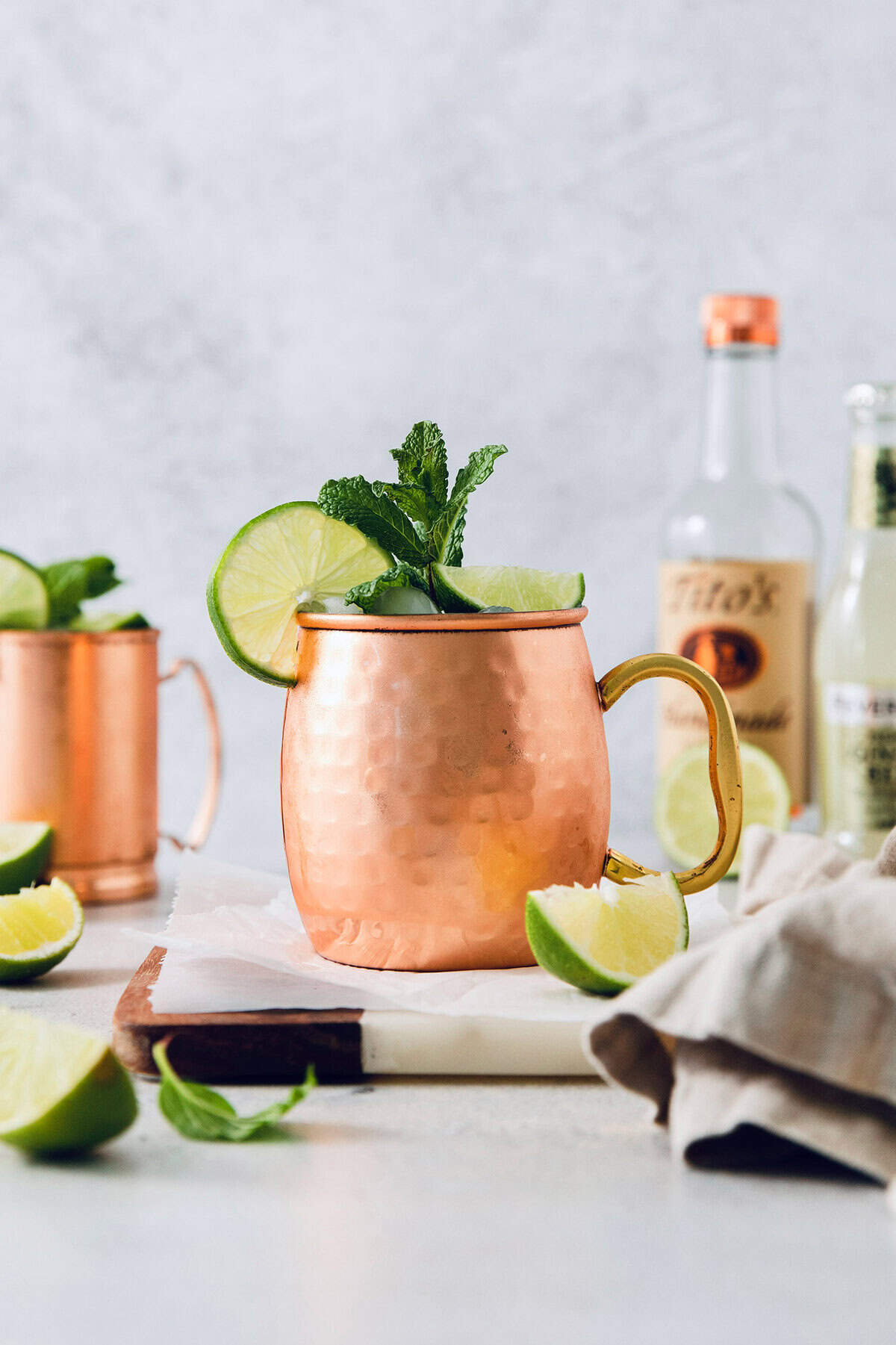 This classic Moscow mule recipe combines lime juice, ginger beer, and vodka with a sprig of fresh mint for a supremely refreshing cocktail! Moscow mule in copper mug with sprig of mint and fresh lime