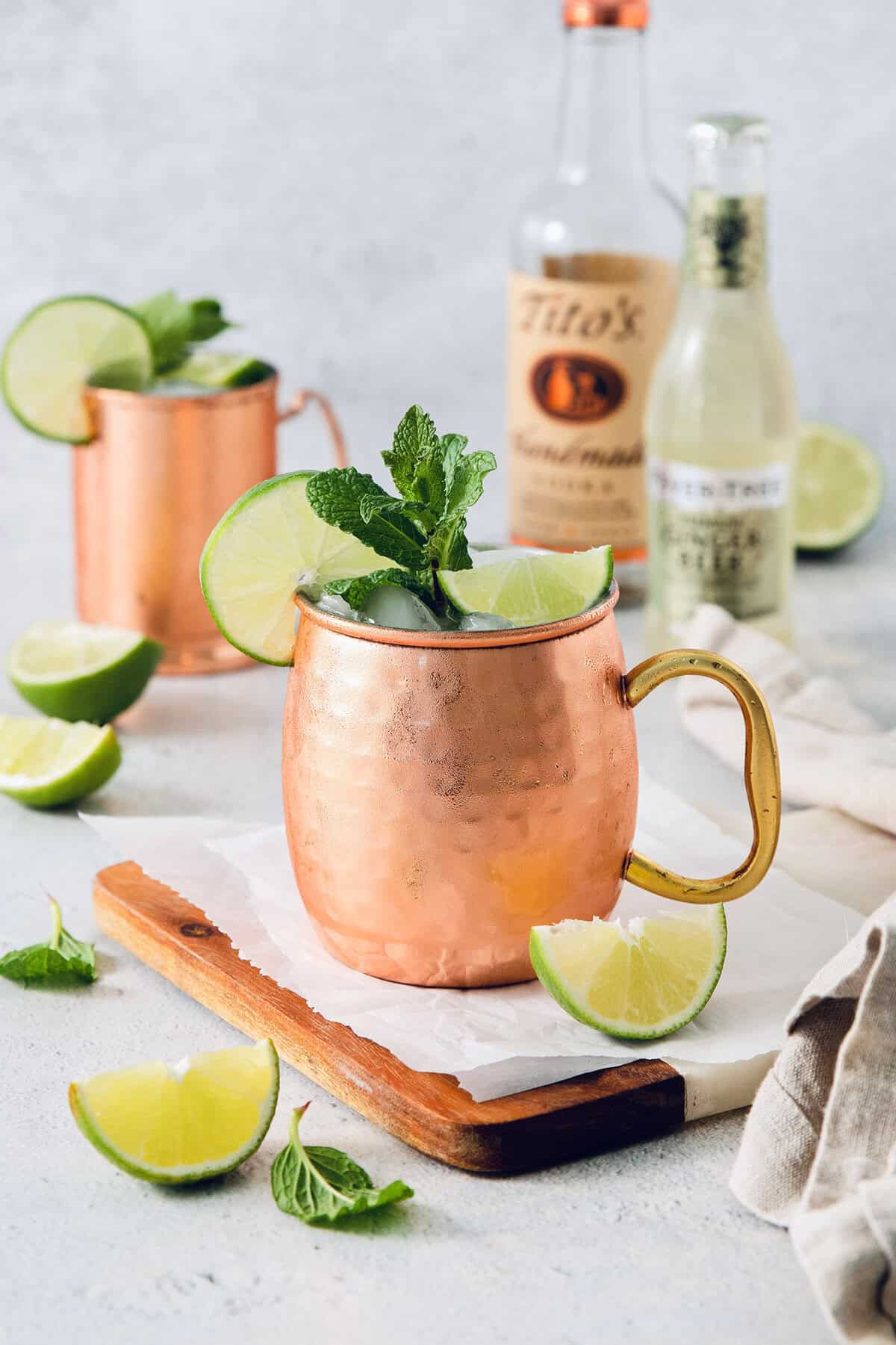This classic Moscow mule recipe combines lime juice, ginger beer, and vodka with a sprig of fresh mint for a supremely refreshing cocktail! Moscow mule in copper mug with sprig of mint and lime wheel on rim
