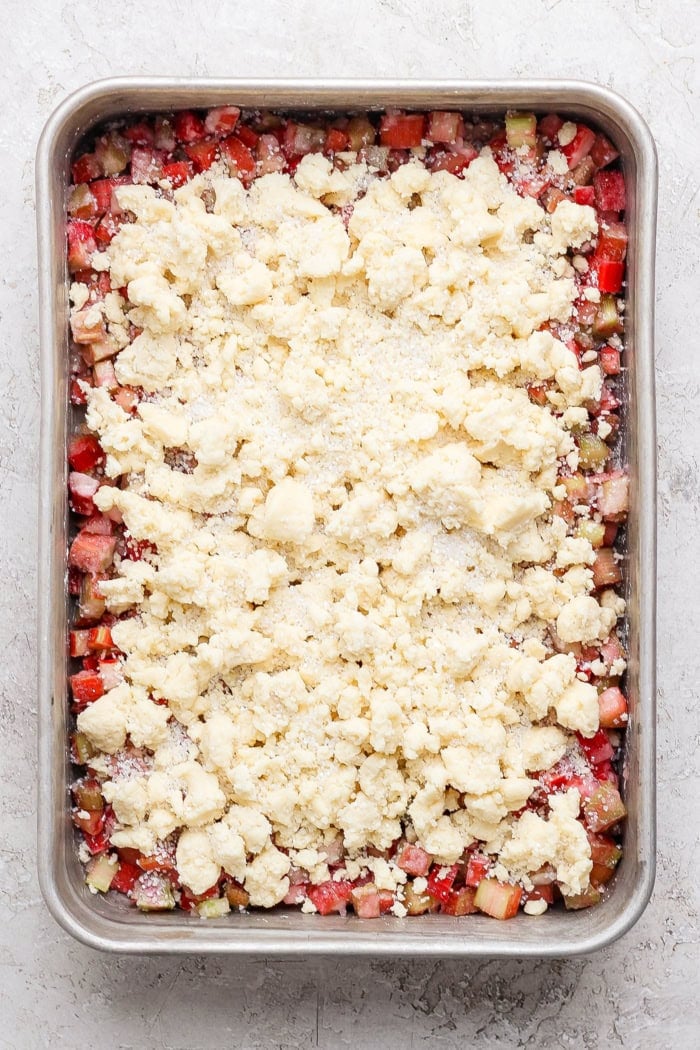Overhead view of assembled rhubarb dump cake in pan before baking