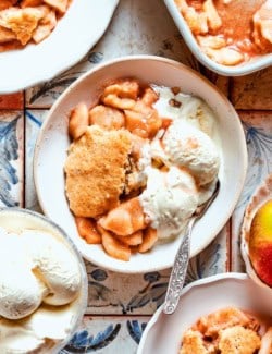 Overhead view of apple cobbler served in bowl with vanilla ice cream