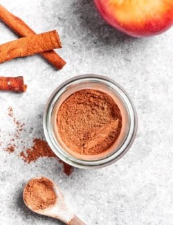 Overhead view of apple pie spice in jar and on measuring spoon