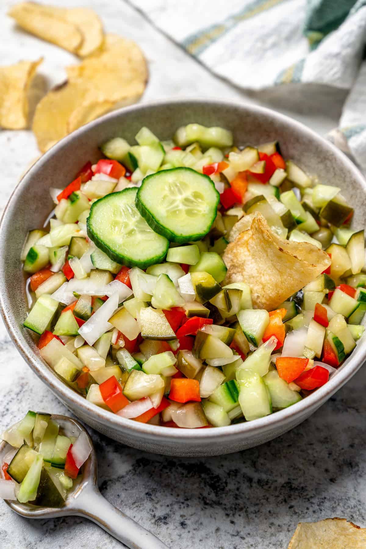 Inspired by Grillo's, this Pickle de Gallo recipe is oh so easy to make and packs in big, briny pickle flavor. Use it as a dip or condiment! Pickle de gallo in bowl with potato chip