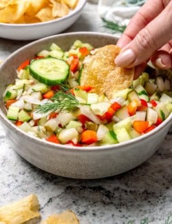 Digging potato chip into bowl of pickle de gallo