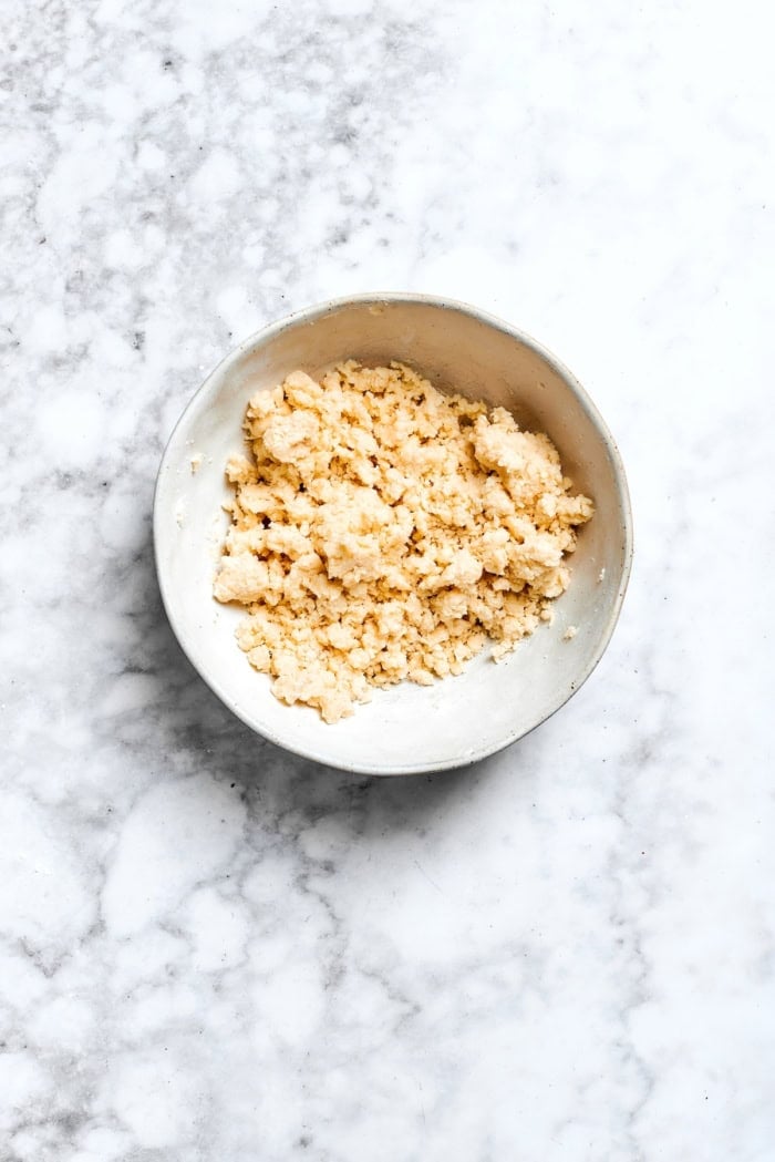 Buttery shortbread is layered with rhubarb custard to create these irresistible Rhubarb Custard Bars. Don't skip the cream cheese topping! Overhead view of crust mixture for rhubarb custard bars in bowl