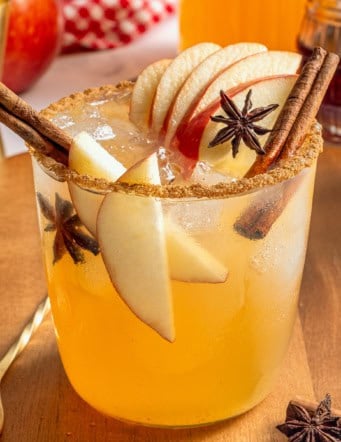 a glass of apple cider margarita with fresh apple slices