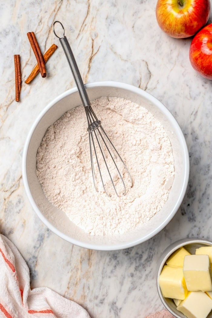 Cake mix and cinnamon in mixing bowl with whisk.