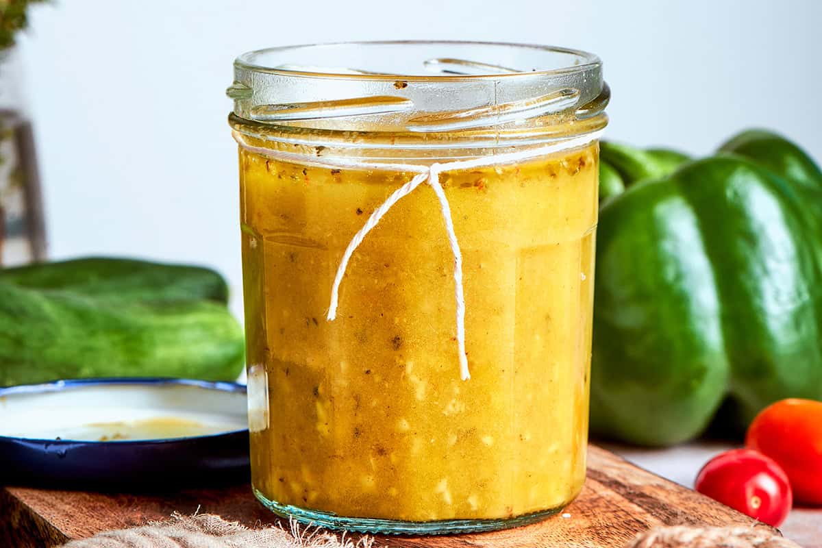 Bright and tangy, with lots of garlic and oregano, this Greek Salad Dressing is easy to make and tastes SO much better than store-bought! Greek salad dressing in a jar, with a piece of kitchen twine tied around the top