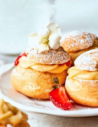 mini cream puffs filled with vanilla pastry cream and fresh strawberry sauce, and dusted with powdered sugar