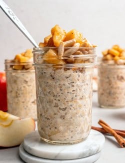 jars of apple overnight oats with sauteed apples and slivered almonds on top