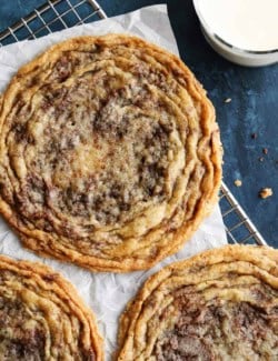 overhead photo of 3 giant pan-banging chocolate chip cookies on a cooling rack