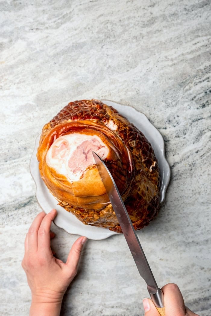 You just need two ingredients for the perfect juicy Crockpot Ham for a crowd! Add the optional glaze and gravy to take it to the next level. Knife scoring ham before cooking.