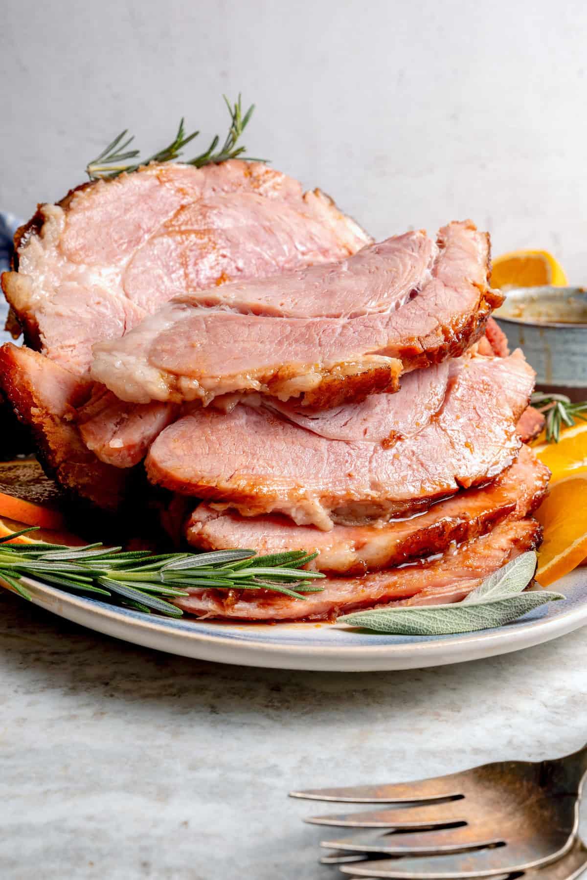 You just need two ingredients for the perfect juicy Crockpot Ham for a crowd! Add the optional glaze and gravy to take it to the next level. Sliced crockpot ham on platter.