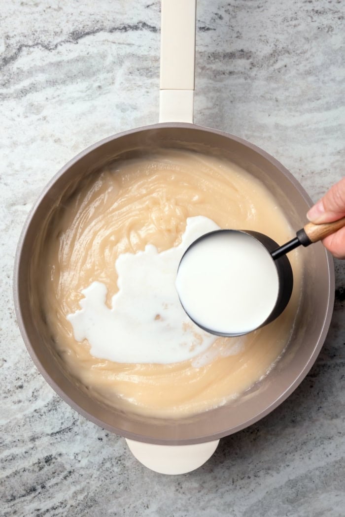 Pouring milk into pan of ham gravy.
