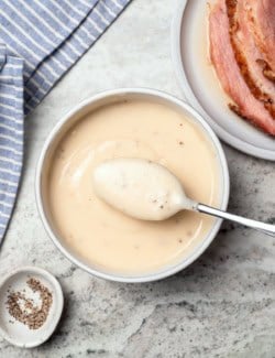 Bowl of ham gravy with spoon.