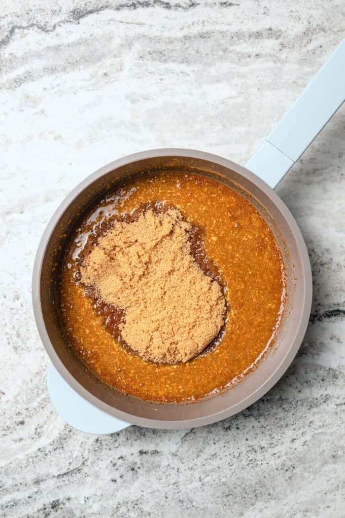 Ingredients for orange-brown sugar ham glaze in saucepan.