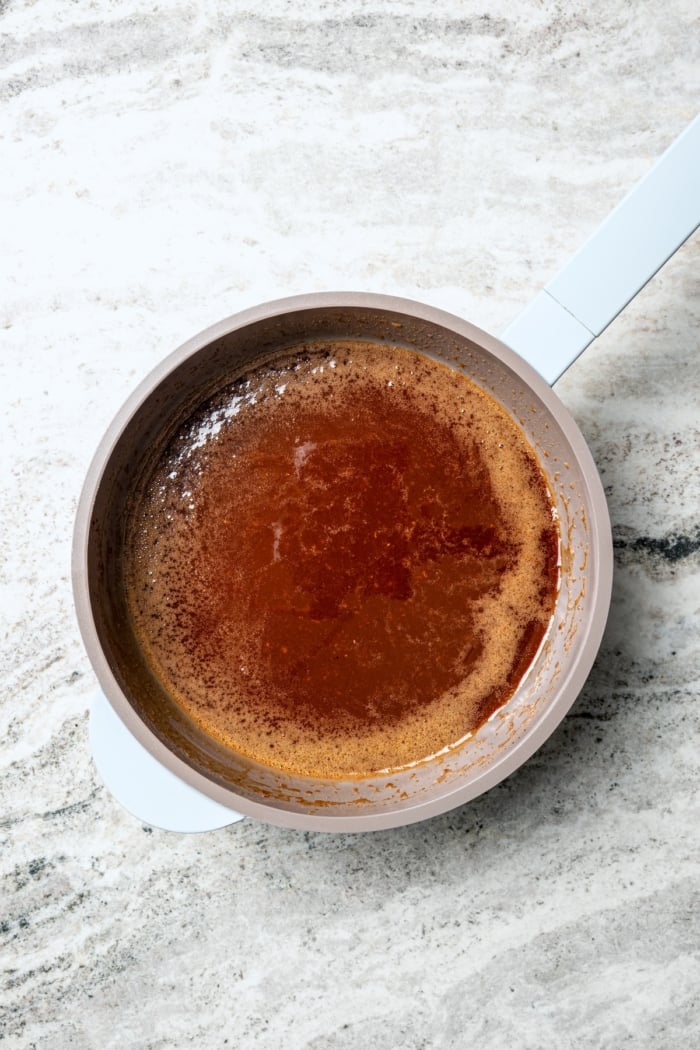 Saucepan with orange-brown sugar ham glaze.