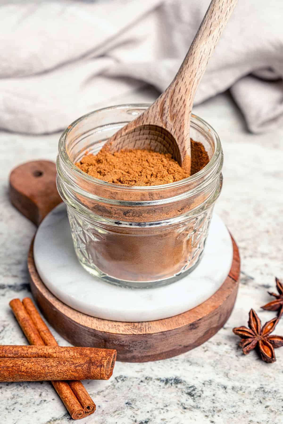 This isn't your ordinary homemade Pumpkin Pie Spice recipe! Itβs rich and robust, with a touch of black pepper for some cozy warmth. a small jar of Pumpkin Pie Spice, with a wooden spoon in the jar