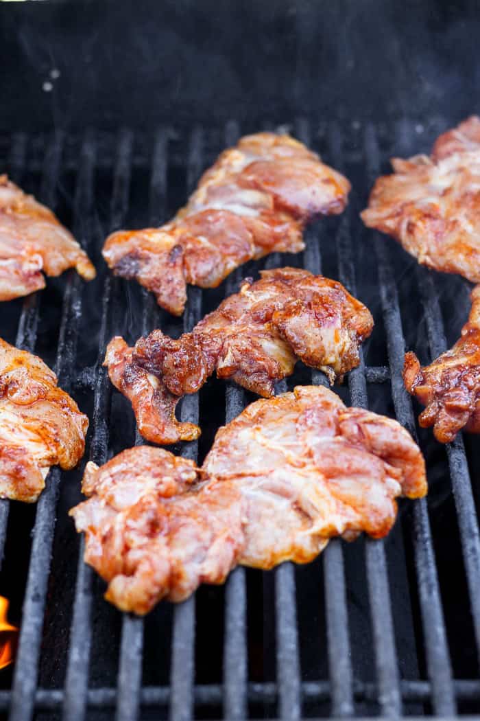 These Grilled Chicken Thighs are tender and juicy, with a smoky char that plays perfectly with the sweet-and-savory seasoning blend. So easy! Chicken thighs on grill.