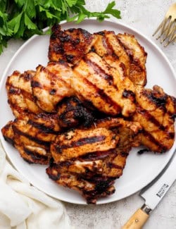 Grilled chicken thighs on plate.